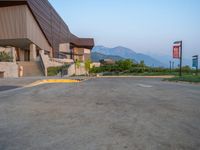 a building that has a bunch of windows on it at sunset with mountains in the background