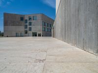 the gray concrete walls of a building have a line of steps on the left side