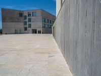 the gray concrete walls of a building have a line of steps on the left side