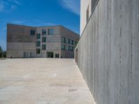 the gray concrete walls of a building have a line of steps on the left side