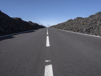 a very empty road going into the mountains in the distance with no cars on it