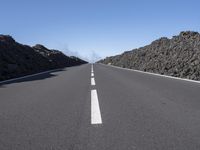 a very empty road going into the mountains in the distance with no cars on it