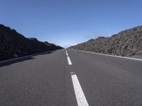 a very empty road going into the mountains in the distance with no cars on it