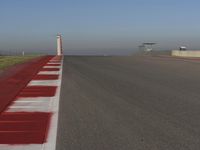 an empty track at a motorsports club with some red and white stripeing on it