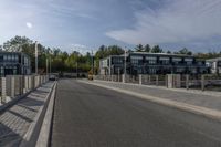 a highway with a parking meter at the end of it and several buildings in the background