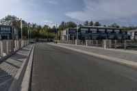 a highway with a parking meter at the end of it and several buildings in the background