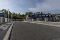 a highway with a parking meter at the end of it and several buildings in the background