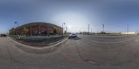 the camera's view of an intersection where a car is driving in front of a large building