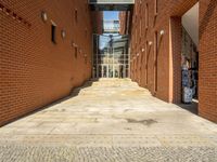 a brick sidewalk with steps and stairs leads to a door that has an entrance way over a platform