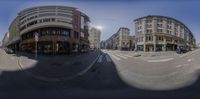 a city intersection, taken with a fish eye lens and the sun in the sky