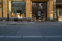 a brown door on the side of an apartment building next to a street with a bench in front