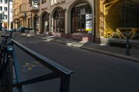 a bike that is leaning on a gate near the street and buildings that have been painted with orange, yellow, white and blue marker markers