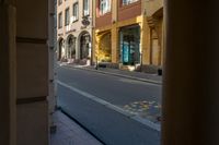 a street that has some very small yellow poles in it and some buildings in the background