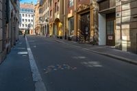 an empty city street with buildings on either side and colored dots painted on the street