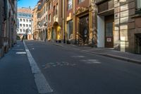 an empty city street with buildings on either side and colored dots painted on the street