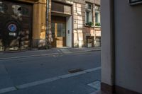 a building that is across from an empty street is lit up in the afternoon sun