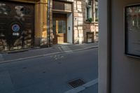 a building that is across from an empty street is lit up in the afternoon sun