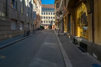 there is a narrow street with buildings in the background and bicycle racks on the curb