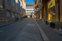 there is a narrow street with buildings in the background and bicycle racks on the curb