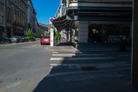 a group of people standing on a sidewalk waiting to cross the street under a crosswalk