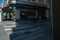 a group of people standing on a sidewalk waiting to cross the street under a crosswalk