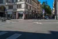 the man is crossing the crosswalk in front of some buildings, with bikes and bicycles on either side