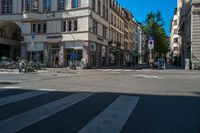 the man is crossing the crosswalk in front of some buildings, with bikes and bicycles on either side