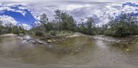 there is a 360 - ray photograph of a stream with water flowing through it and trees in the background