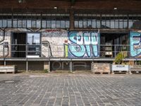 an old factory with graffiti and a sign with the word'still shut'in blue