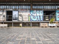 an old factory with graffiti and a sign with the word'still shut'in blue