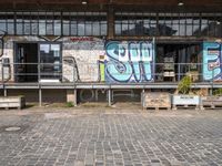 an old factory with graffiti and a sign with the word'still shut'in blue