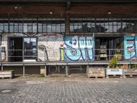 an old factory with graffiti and a sign with the word'still shut'in blue