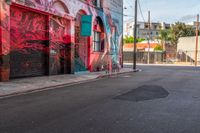 a fire hydrant on the side of a road with red graffiti painted all over it