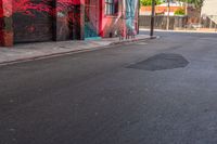 a fire hydrant on the side of a road with red graffiti painted all over it