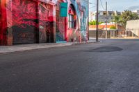 a fire hydrant on the side of a road with red graffiti painted all over it