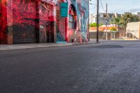 a fire hydrant on the side of a road with red graffiti painted all over it