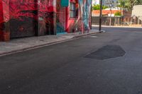 a fire hydrant on the side of a road with red graffiti painted all over it