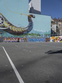 this is an outdoor public space with a mural of an elephant on the side of a building