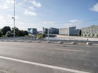 an image of a broken microwave lying in the street by some buildings near an empty road