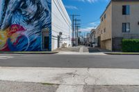 a colorful mural on the side of a building on the corner is an empty street