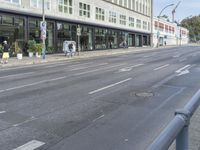 a street in a city has a bicycle lane and several pedestrians on it is in the distance