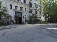 the street is empty and it is lined with trees and buildings, which are also empty