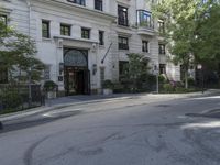 the street is empty and it is lined with trees and buildings, which are also empty