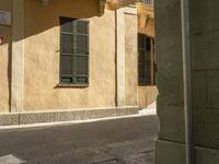 there is a street corner with a traffic light on it as well as a building and a small window