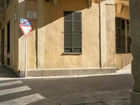 there is a street corner with a traffic light on it as well as a building and a small window