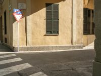 there is a street corner with a traffic light on it as well as a building and a small window