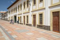 a street with some houses in front of a hill range in ecuador by an electric line