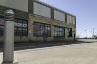 a motorcycle shop along a street with a sign attached to the side wall next to it