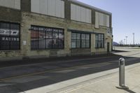 a motorcycle shop along a street with a sign attached to the side wall next to it