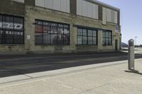 a motorcycle shop along a street with a sign attached to the side wall next to it